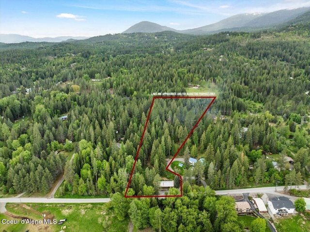 1072 Upland Dr, Sandpoint, ID 83864 - aerial view of property's location featuring a heavily wooded area, a mountainous background, and property parcel outlined