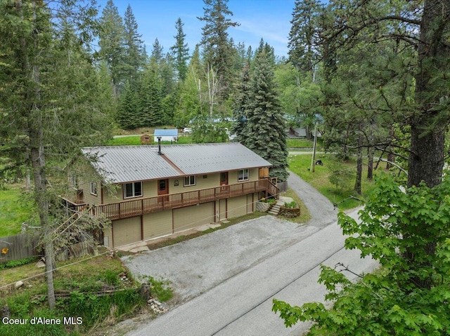 1072 Upland Dr, Sandpoint, ID 83864 - view of front facade with stairs, driveway, a garage, and metal roof