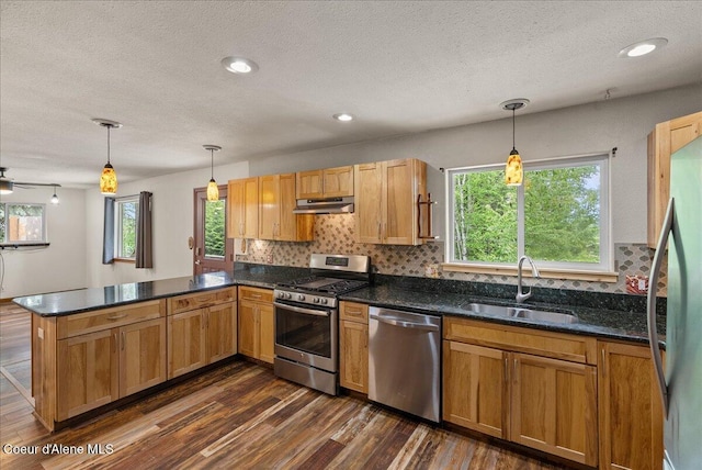 1072 Upland Dr, Sandpoint, ID 83864 - kitchen with appliances with stainless steel finishes, under cabinet range hood, a sink, a peninsula, and a textured ceiling