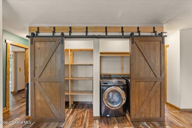 1072 Upland Dr, Sandpoint, ID 83864 - laundry area with washer / dryer, a barn door, wood finished floors, and a textured ceiling