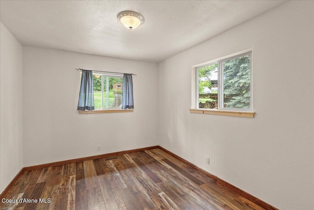 1072 Upland Dr, Sandpoint, ID 83864 - unfurnished room with healthy amount of natural light, dark wood-style flooring, and baseboards