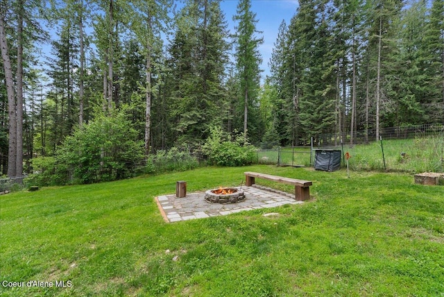 1072 Upland Dr, Sandpoint, ID 83864 - view of yard featuring an outdoor fire pit, a patio area, and a view of trees