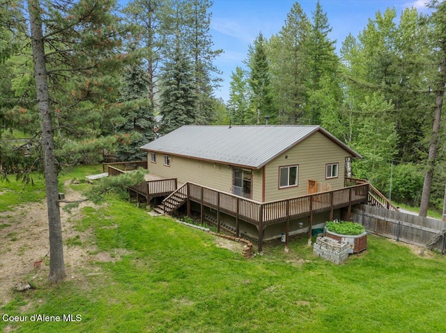 1072 Upland Dr, Sandpoint, ID 83864 - rear view of property featuring a deck, a wooded view, and metal roof