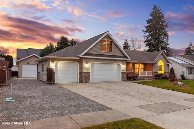 5519 N Wade St, Coeur Dalene, ID 83815 - view of front of property featuring covered porch, stone siding, a shingled roof, an attached garage, and concrete driveway