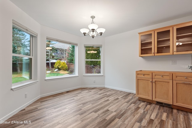 5519 N Wade St, Coeur Dalene, ID 83815 - unfurnished dining area featuring a chandelier, light wood-type flooring, and baseboards