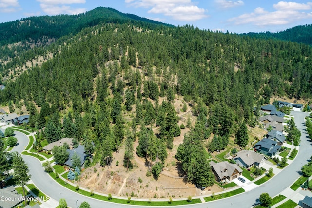 5519 N Wade St, Coeur Dalene, ID 83815 - aerial view of property's location featuring a heavily wooded area, a mountain backdrop, and nearby suburban area