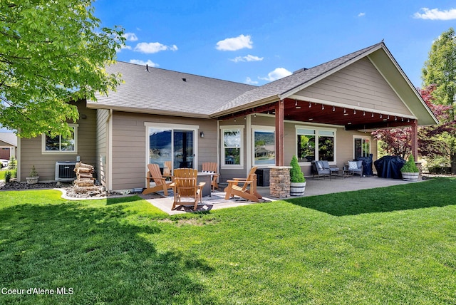 14097 N Pristine Cir, Rathdrum, ID 83858 - rear view of property featuring a patio area, central AC unit, a shingled roof, and a yard