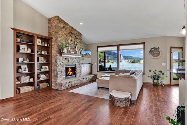 14097 N Pristine Cir, Rathdrum, ID 83858 - living area featuring wood finished floors, a stone fireplace, vaulted ceiling, and baseboards