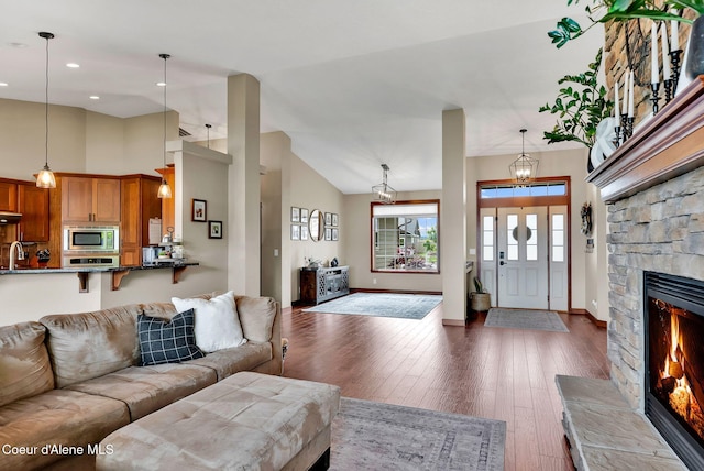 14097 N Pristine Cir, Rathdrum, ID 83858 - living area with dark wood finished floors, a fireplace, lofted ceiling, recessed lighting, and baseboards