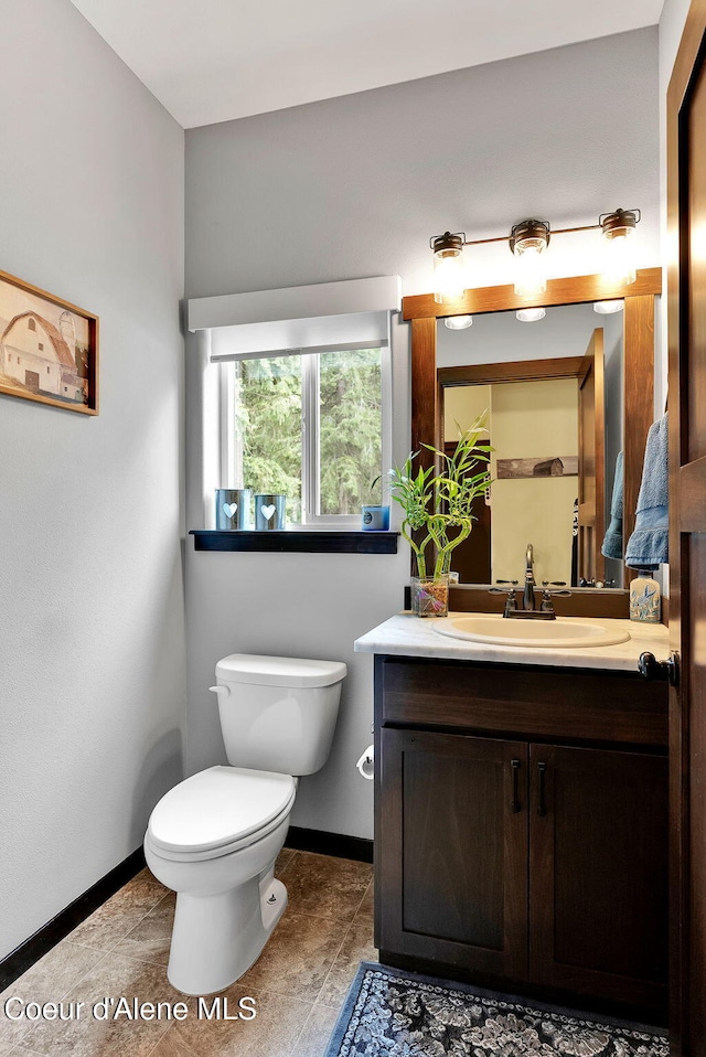 17940 W Sheltered Ct, Hauser, ID 83854 - bathroom with baseboards, toilet, vanity, and tile patterned floors