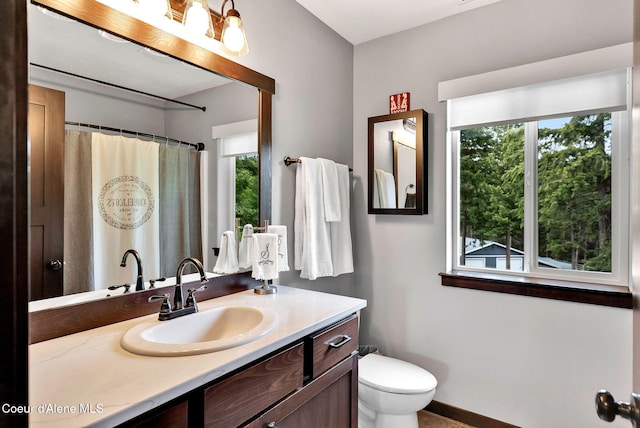 17940 W Sheltered Ct, Hauser, ID 83854 - bathroom featuring vanity, toilet, a shower with curtain, and baseboards