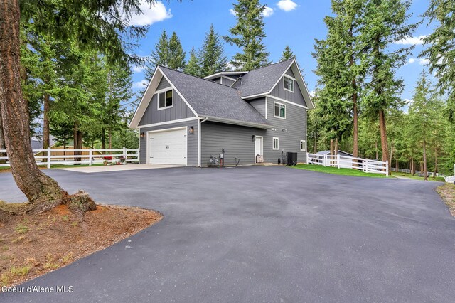 17940 W Sheltered Ct, Hauser, ID 83854 - view of side of property featuring roof with shingles, board and batten siding, and driveway