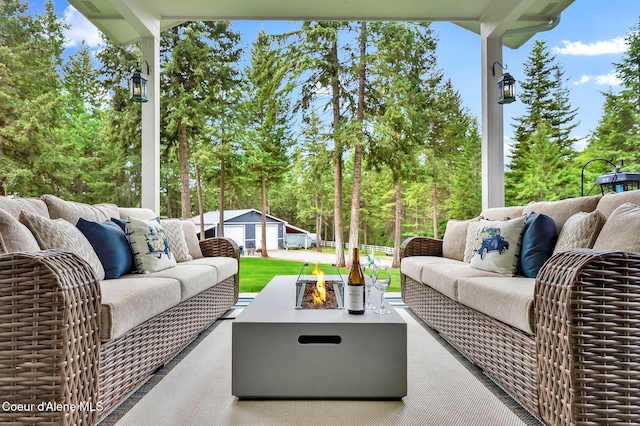 17940 W Sheltered Ct, Hauser, ID 83854 - view of patio with an outdoor living space with a fire pit, an outdoor structure, and view of scattered trees