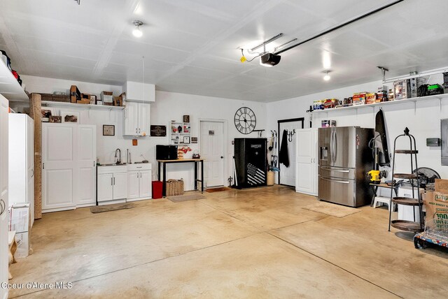 17940 W Sheltered Ct, Hauser, ID 83854 - garage with stainless steel fridge and a garage door opener
