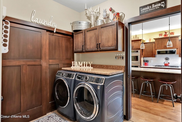 17940 W Sheltered Ct, Hauser, ID 83854 - washroom with washing machine and dryer and light wood-style floors