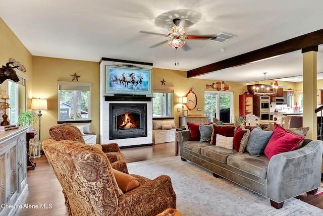 17940 W Sheltered Ct, Hauser, ID 83854 - living area with a large fireplace, a chandelier, ceiling fan, wood finished floors, and beam ceiling