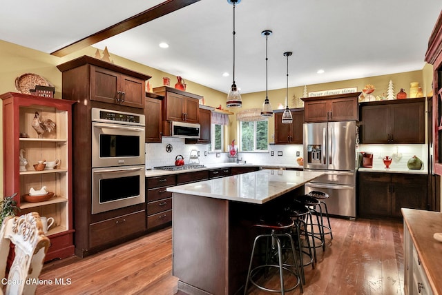 17940 W Sheltered Ct, Hauser, ID 83854 - kitchen with stainless steel appliances, light wood finished floors, light countertops, decorative backsplash, and recessed lighting