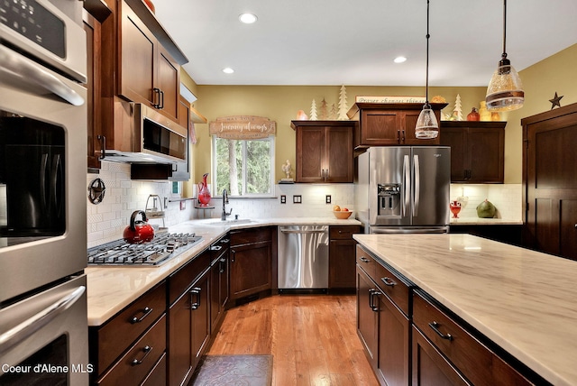 17940 W Sheltered Ct, Hauser, ID 83854 - kitchen with appliances with stainless steel finishes, a sink, light countertops, light wood-style flooring, and recessed lighting