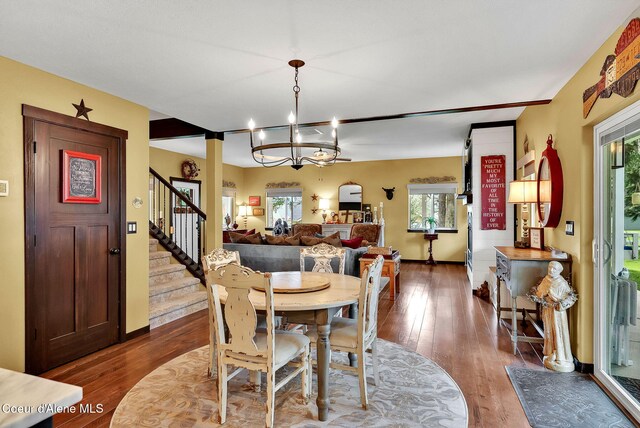 17940 W Sheltered Ct, Hauser, ID 83854 - dining room with dark wood finished floors, stairway, a chandelier, and baseboards