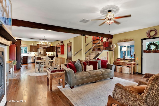 17940 W Sheltered Ct, Hauser, ID 83854 - living room featuring a chandelier, ceiling fan, hardwood / wood-style floors, stairs, and beam ceiling