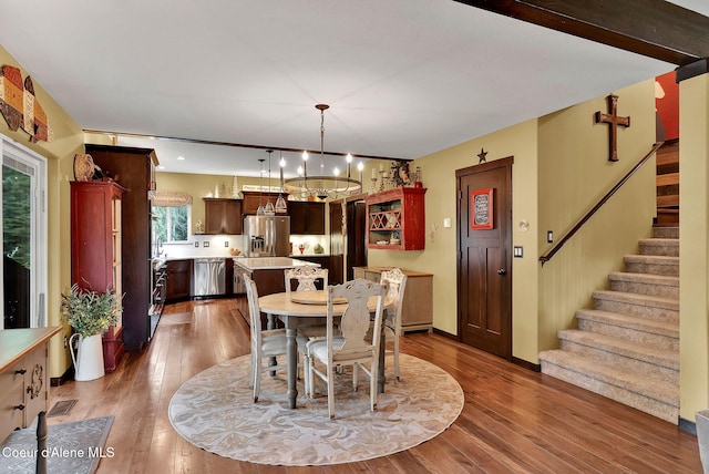 17940 W Sheltered Ct, Hauser, ID 83854 - dining room with stairway, a chandelier, and dark wood-type flooring