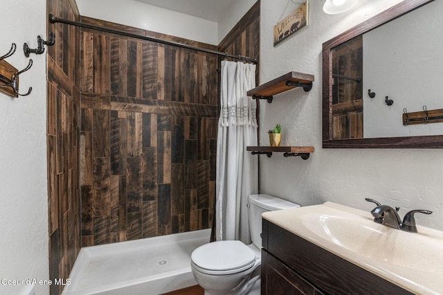 603 Schneiders Rd, Sagle, ID 83860 - bathroom featuring a textured wall, toilet, tiled shower, and vanity