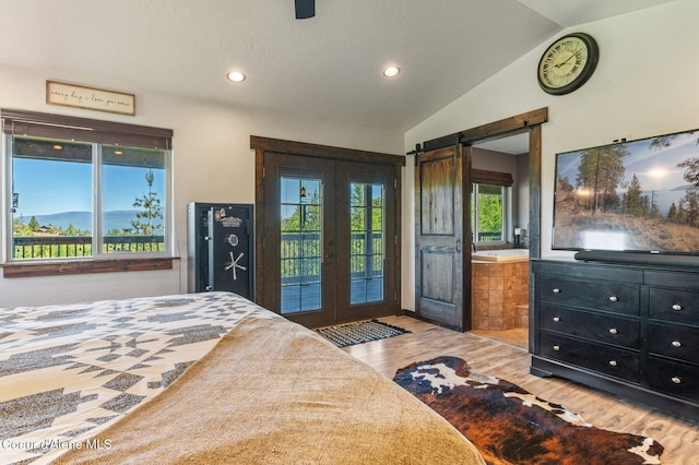 603 Schneiders Rd, Sagle, ID 83860 - bedroom featuring access to exterior, wood finished floors, vaulted ceiling, a barn door, and french doors
