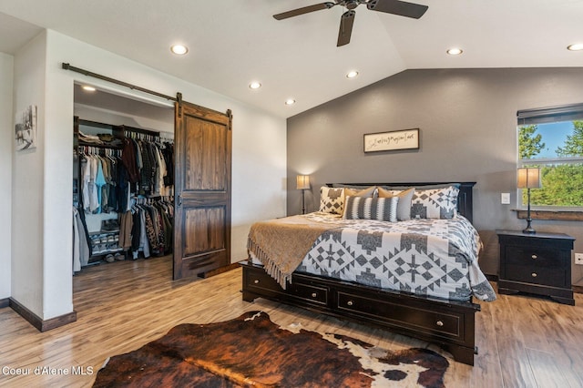 603 Schneiders Rd, Sagle, ID 83860 - bedroom with a barn door, light wood-type flooring, lofted ceiling, recessed lighting, and a spacious closet