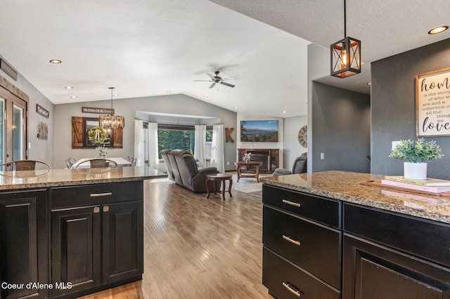 603 Schneiders Rd, Sagle, ID 83860 - kitchen featuring lofted ceiling, dark cabinetry, a ceiling fan, light wood-style floors, and decorative light fixtures