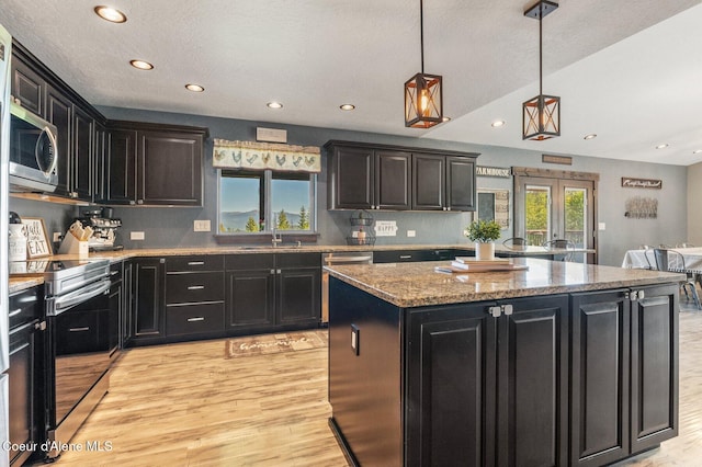 603 Schneiders Rd, Sagle, ID 83860 - kitchen with stainless steel appliances, dark cabinetry, light wood finished floors, recessed lighting, and a center island