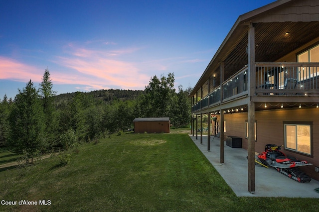 603 Schneiders Rd, Sagle, ID 83860 - yard at dusk with a patio, a yard, and a wooden deck