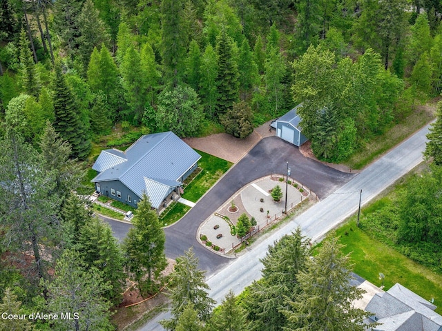 aerial view of property and surrounding area with a heavily wooded area