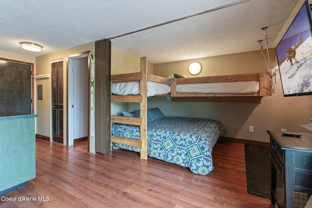 495 NW Psge # 103, Sandpoint, ID 83864 - bedroom featuring baseboards, wood finished floors, and a textured ceiling