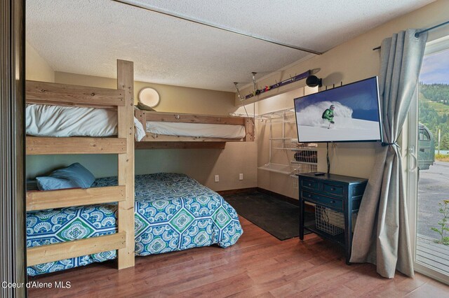495 NW Psge # 103, Sandpoint, ID 83864 - bedroom featuring wood finished floors, a textured ceiling, and baseboards