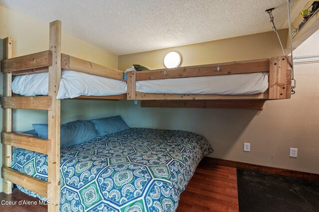 495 NW Psge # 103, Sandpoint, ID 83864 - bedroom featuring wood finished floors, baseboards, and a textured ceiling