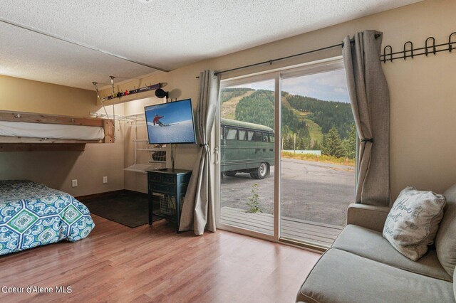 495 NW Psge # 103, Sandpoint, ID 83864 - bedroom with access to outside, wood finished floors, a textured ceiling, and baseboards