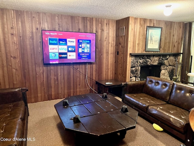 495 NW Psge # 103, Sandpoint, ID 83864 - carpeted cinema room featuring wood walls, a textured ceiling, and a stone fireplace
