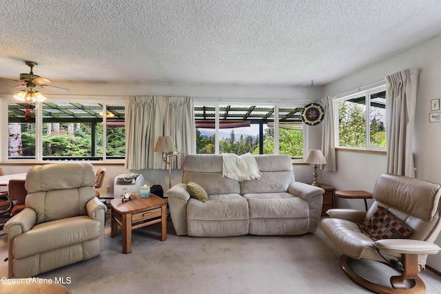 carpeted living area with a textured ceiling and a ceiling fan