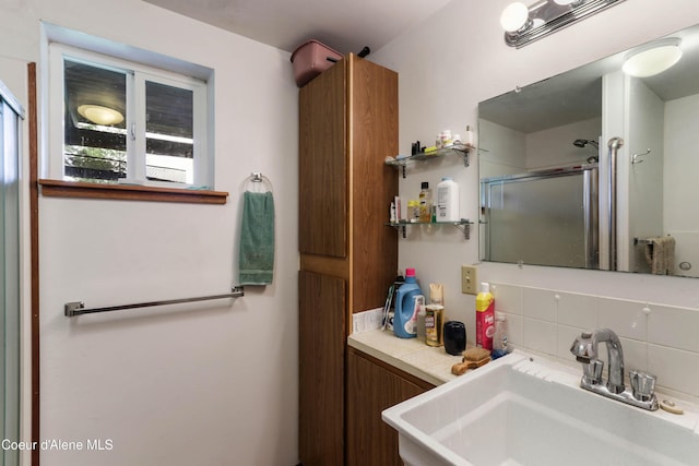 full bath with a sink, backsplash, and a stall shower
