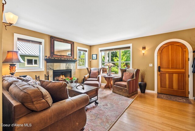 619 N Florence Ave, Sandpoint, ID 83864 - living room featuring a tile fireplace, light wood-style floors, arched walkways, and baseboards