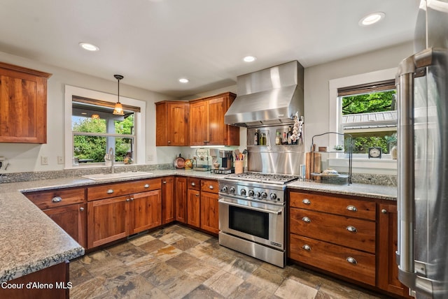 619 N Florence Ave, Sandpoint, ID 83864 - kitchen featuring appliances with stainless steel finishes, wall chimney exhaust hood, a sink, stone finish floors, and recessed lighting
