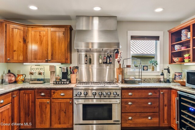 619 N Florence Ave, Sandpoint, ID 83864 - kitchen with appliances with stainless steel finishes, wall chimney range hood, beverage cooler, recessed lighting, and light stone countertops