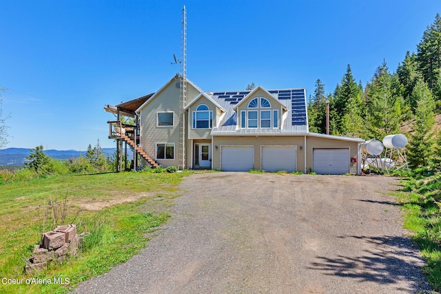multi unit property featuring stairs, a garage, dirt driveway, and a deck