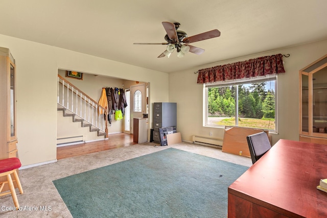 carpeted office space featuring a baseboard radiator, ceiling fan, and baseboards
