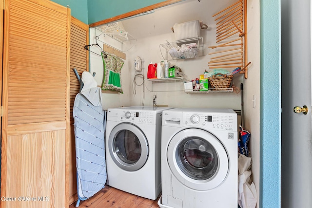 washroom featuring washer and clothes dryer and light wood-style flooring
