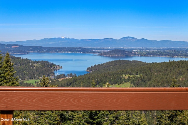 mountain view featuring a nearby body of water and a forest