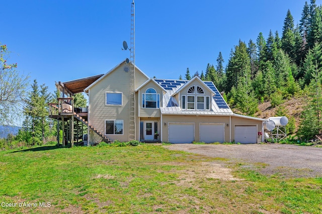 view of front of home with stairs, a front lawn, a garage, driveway, and a deck