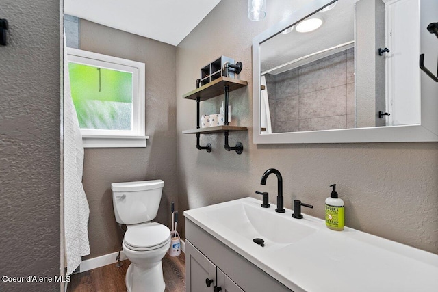 908 E Coeur D Alene Ave, Coeur Dalene, ID 83814 - bathroom featuring a textured wall, wood finished floors, toilet, vanity, and curtained shower