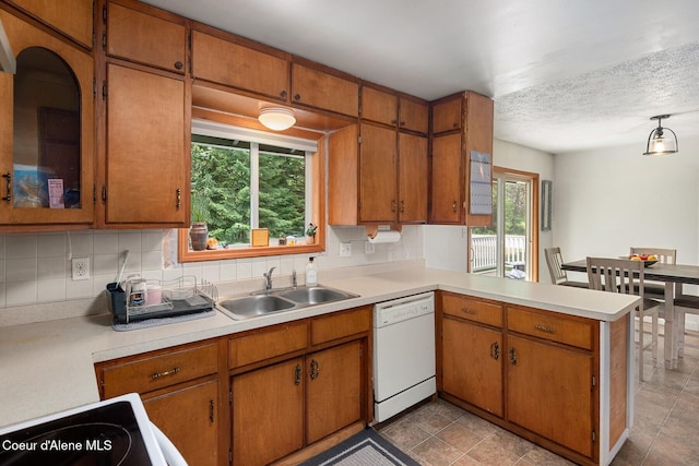 42 Bodie Ln, Priest River, ID 83856 - kitchen featuring white dishwasher, a sink, light countertops, tasteful backsplash, and a textured ceiling