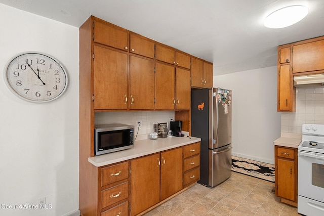 42 Bodie Ln, Priest River, ID 83856 - kitchen featuring stainless steel appliances, light countertops, under cabinet range hood, and backsplash
